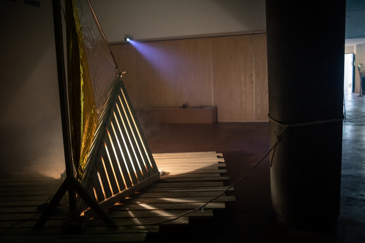 Le radeau de la fabulation, 2020, installation bois, couverture de survie, lampe, enceintes et enregistrement sonore par Charlie Wellecam